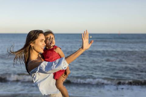 Mother and daughter standing on the beach at sunset model released Symbolfoto  MAUF01929