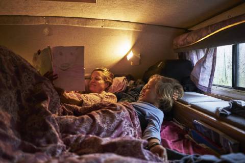 Mother looking at son s drawings lying in bed of a camper model released Symbolfoto property released  SSCF00180
