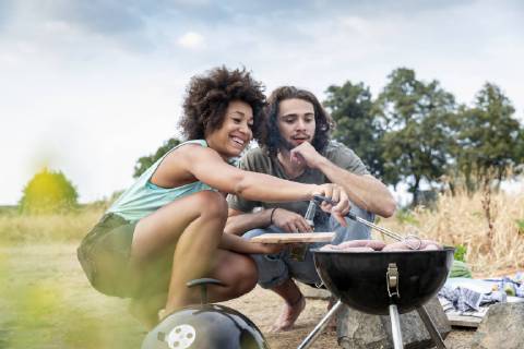 Happy couple having a barbecue in the nature model released Symbolfoto  FMKF05279