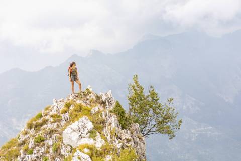 Italy, Massa, young woman standing on top of a peak in the Alpi Apuane mountains model released Symbolfoto  WPEF00863