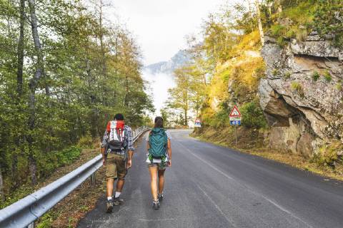Italy, Massa, rear view of young couple walking on asphalt road in the Alpi Apuane mountains model released Symbolfoto  WPEF00911