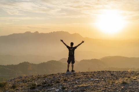 Spain, Barcelona, Natural Park of Sant Llorenc, man hiking and cheering at sunset model released Symbolfoto  AFVF01890