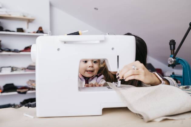 Little daughter watching her mother using sewing machine at home model released Symbolfoto property released  JRFF02085