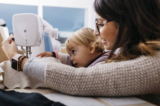 Happy mother with little daughter at home using sewing machine model released Symbolfoto property released  JRFF02086