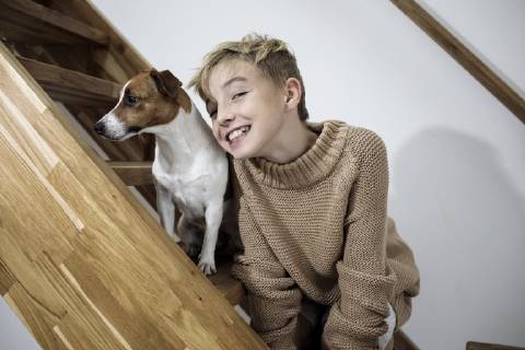Portrait of grinning boy and his Jack Russel Terrier on stairs at home model released Symbolfoto property released  KMKF00650