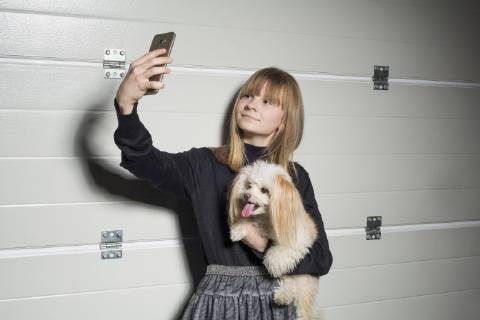Girl with dog taking selfie with camera phone in garage  Copyright: VladimirxGodnik fStopImages1810033