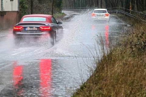 Dangerous road conditions during heavy rain The water from a road flooded after heavy rain is torn into the air by the cars and causes many drivers to be terrified Essen Nordrhein Westfalen Germany Deutschland Überruhr