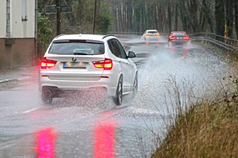 Dangerous road conditions during heavy rain The water from a road flooded after heavy rain is torn into the air by the cars and causes many drivers to be terrified Essen Nordrhein Westfalen Germany Deutschland Überruhr
