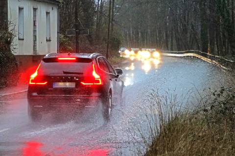 Dangerous road conditions during heavy rain The water from a road flooded after heavy rain is torn into the air by the cars and causes many drivers to be terrified Essen Nordrhein Westfalen Germany Deutschland Überruhr