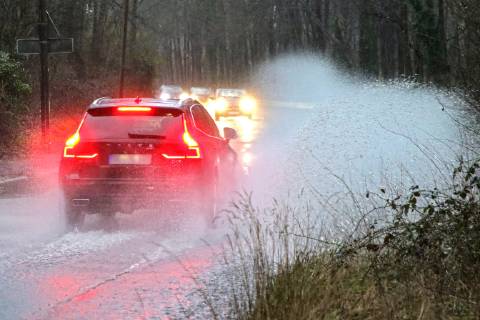 Dangerous road conditions during heavy rain The water from a road flooded after heavy rain is torn into the air by the cars and causes many drivers to be terrified Essen Nordrhein Westfalen Germany Deutschland Überruhr