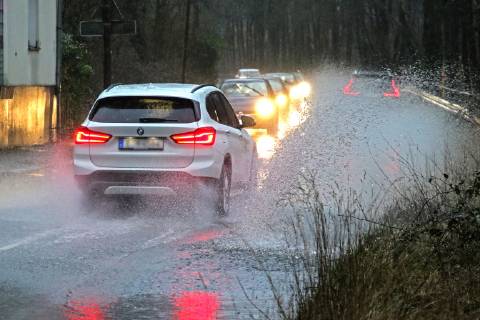 Dangerous road conditions during heavy rain The water from a road flooded after heavy rain is torn into the air by the cars and causes many drivers to be terrified Essen Nordrhein Westfalen Germany Deutschland Überruhr