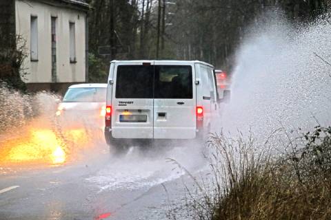 Dangerous road conditions during heavy rain The water from a road flooded after heavy rain is torn into the air by the cars and causes many drivers to be terrified Essen Nordrhein Westfalen Germany Deutschland Überruhr