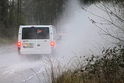 Dangerous road conditions during heavy rain The water from a road flooded after heavy rain is torn into the air by the cars and causes many drivers to be terrified Essen Nordrhein Westfalen Germany Deutschland Überruhr