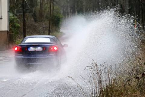 Dangerous road conditions during heavy rain The water from a road flooded after heavy rain is torn into the air by the cars and causes many drivers to be terrified Essen Nordrhein Westfalen Germany Deutschland Überruhr