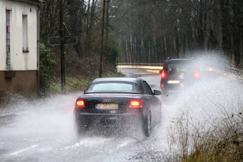 Dangerous road conditions during heavy rain The water from a road flooded after heavy rain is torn into the air by the cars and causes many drivers to be terrified Essen Nordrhein Westfalen Germany Deutschland Überruhr