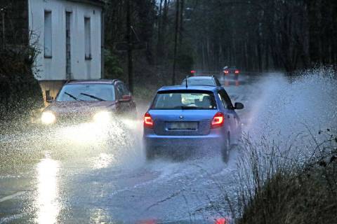 Dangerous road conditions during heavy rain The water from a road flooded after heavy rain is torn into the air by the cars and causes many drivers to be terrified Essen Nordrhein Westfalen Germany Deutschland Überruhr