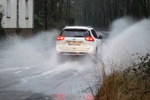 Dangerous road conditions during heavy rain The water from a road flooded after heavy rain is torn into the air by the cars and causes many drivers to be terrified Essen Nordrhein Westfalen Germany Deutschland Überruhr