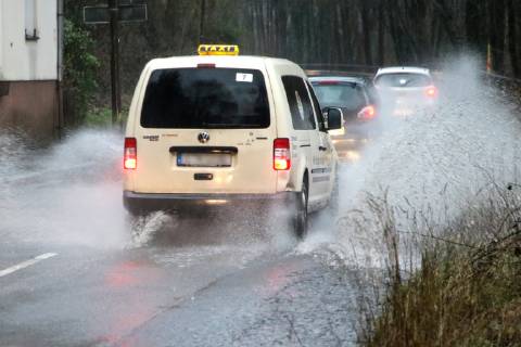 Dangerous road conditions during heavy rain The water from a road flooded after heavy rain is torn into the air by the cars and causes many drivers to be terrified Essen Nordrhein Westfalen Germany Deutschland Überruhr