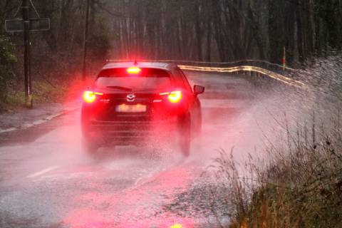 Dangerous road conditions during heavy rain The water from a road flooded after heavy rain is torn into the air by the cars and causes many drivers to be terrified Essen Nordrhein Westfalen Germany Deutschland Überruhr
