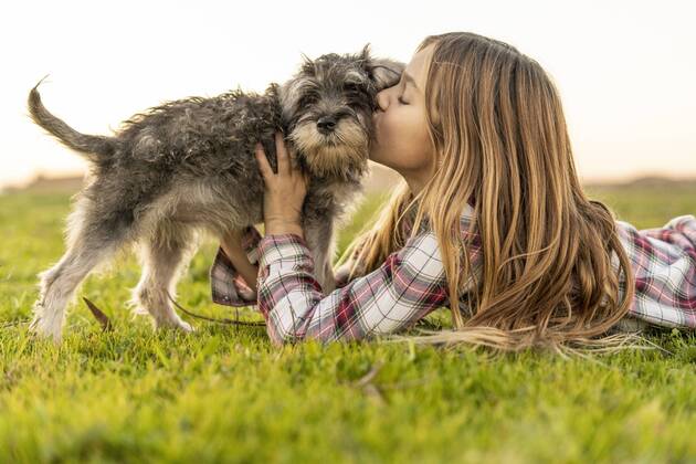 Girl lying on a meadow kissing her dog model released Symbolfoto property released  ERRF00687