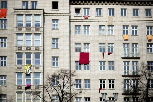 Mietendemo DEU, Deutschland, Germany, Berlin, 06.04.2019 Protestfahnen an der Fassade von Wohnhaus an der Karl-Marx-Allee in Berlin Friedrichshain. Bis auf kurzem hingen hier Protestplakate gehen den Immobilienkonzern Deutsche Wohnen, welche hier Wohnungen erwerben wollte. Demonstration von Mieterorganisationen und politischen Initiativen gegen hohe steigende Mieten, teure Modernisierungen, Gentrifizierung, Verdraengung und Zwangsraeumungen unter dem Motto Widerstand Gemeinsam gegen Verdraengung und Mieterwahnsinn, Mieten Wahnsinn stoppen Mietenwahnsinn in Berlin. Ueber 35.000 Menschen protestieren auf einer Grossdemonstration von 240 Mieterinitiativen. Protest gehen den Immobilienkonzern Deutsche Wohnen, welche hier Wohnungen erwerben wollte. Poster on a Fassade of a building at the Karl-Marx-Allee in Berlin, Germany. Until shortly Pr