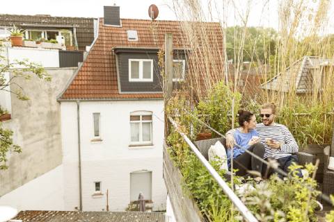 Young couple relaxing on their balcony, sitting on couch model released Symbolfoto property released  PESF01158