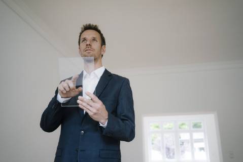 Businessman using glass touch screen in a new home model released Symbolfoto property released  KNSF05473