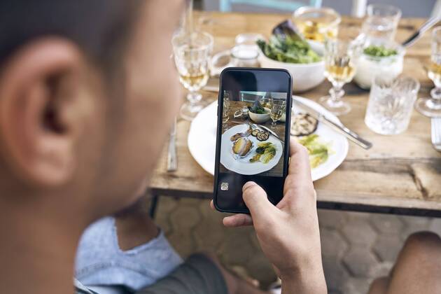 Man taking a picture of the food at a barbecue party model released Symbolfoto property released  PDF01845