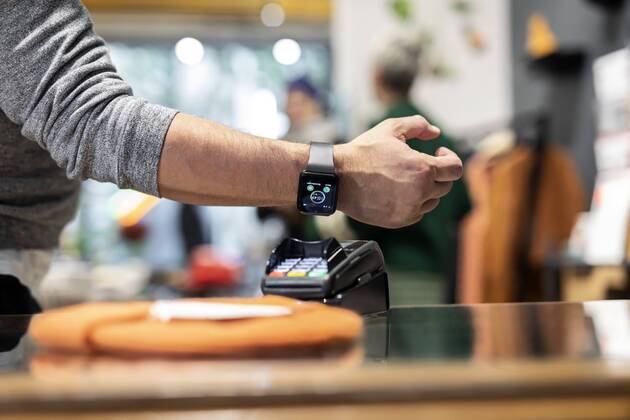 Customer paying contactless with his smartwatch model released Symbolfoto property released  PESF01529