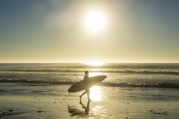 USA, California, Del Mar, Surfer at the beach against the sun model released Symbolfoto  RUNF01127
