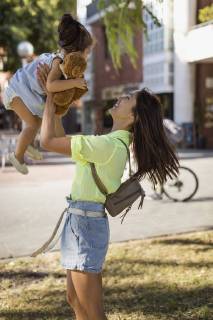 Happy mother lifting up daughter outdoors in the city model released Symbolfoto  MAUF02397