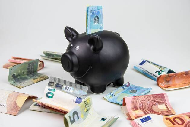 Symbol photo black piggy bank with euro banknotes and coins piggy bank and money