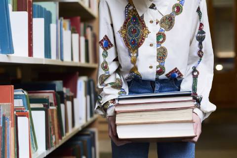 Female student with books in a public library model released Symbolfoto  IGGF01057
