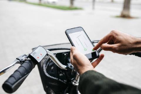 Close-up of man with e-bikeusing smartphone navigation system model released Symbolfoto property released  JRFF02959