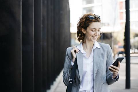 Businesswoman with smartphone, commuting in the city model released Symbolfoto  JRFF03058