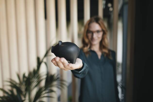 Businesswoman holding piggy bank model released Symbolfoto property released  GUSF01916