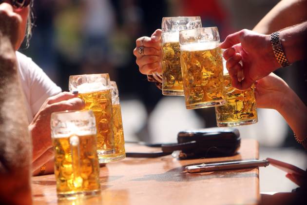 Joint frosting with beer mugs in the beer garden at Viktualienmarkt in Munich, Bavaria, Germany