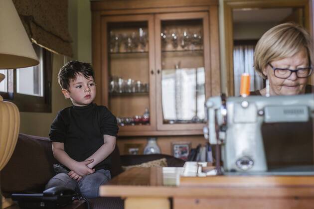 Grandmother using an old sewing machine watched by her grandson model released Symbolfoto property released  LJF00090