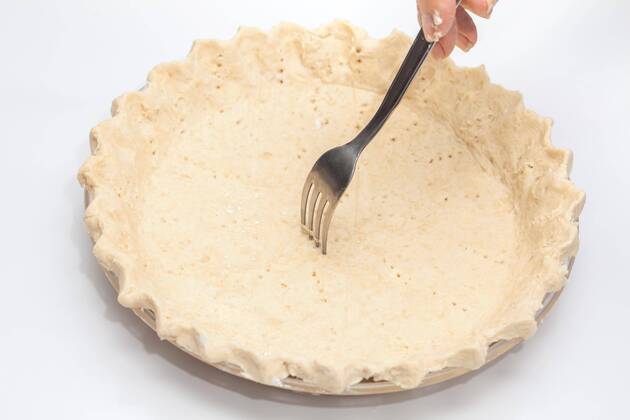  Quiche lorraine preparation : Making little holes with a fork on the quiche lorraine dough  Copyright: xanamejia18x Panthermedia19755807