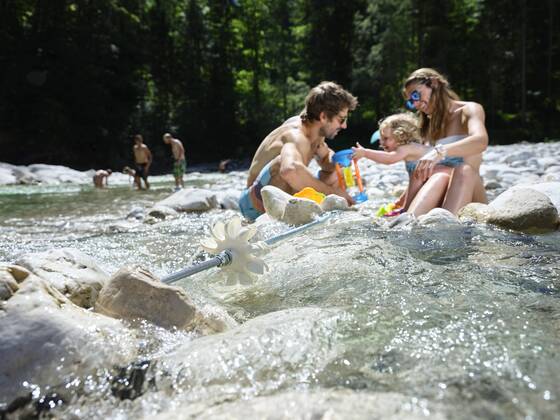 Family with daughter playing in a mountain stream model released Symbolfoto  CVF01375
