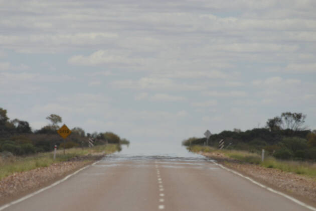 Australia - Heat Haze merges the road. with the sky in outback, near Coober Pedy. South Australia.  Copyright: DonxHadden 10858079