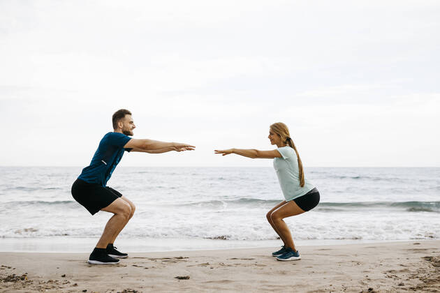 Young couple during training on the beach model released Symbolfoto  JRFF03671