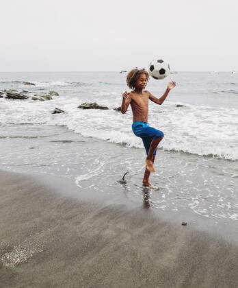Freizeit Trend: Football Freestyle Boy playing with a football on the beach model released Symbolfoto  LJF00988