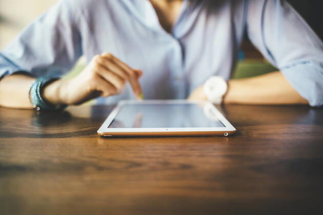 Woman sitting in a cafe using a digital tablet model released Symbolfoto OYF00050