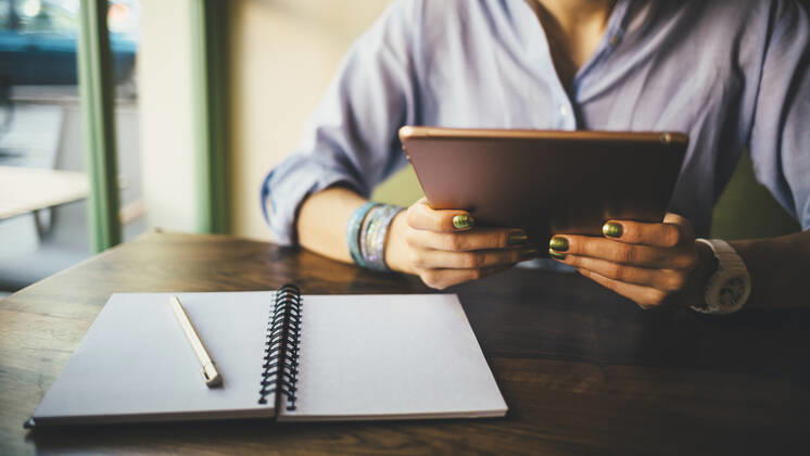 Woman sitting in a cafe using a digital tablet model released Symbolfoto OYF00052