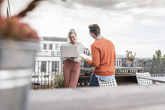 Casual businessman and woman with laptop meeting on roof terrace model released Symbolfoto property released  UUF18550