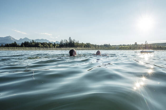 Two girls swimming in a lake in sunshine, Bannwaldsee, Allgaeu, Bavaria, Germany model released Symbolfoto  WFF00088