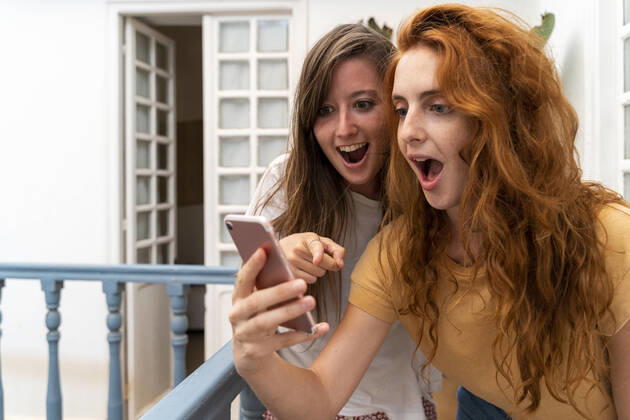 Portrait of two excited friends looking at smartphone model released Symbolfoto  AFVF03961
