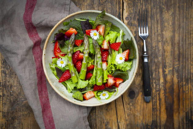 Close-up of salad with green asparagus, strawberries and daisies  LVF08316
