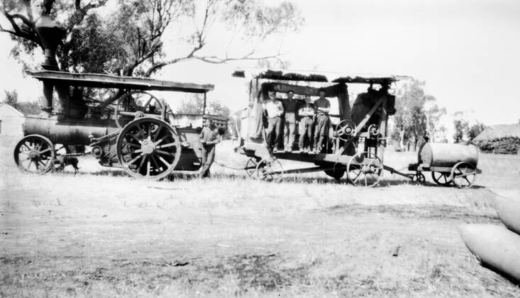 Negative - Coleambally Area, New South Wales, 1931, A traction steam engine pulling a Buncle chaffcutter and a Furphy water cart which supplied water for the steam engine. A number of men are standing on the chaffcutter. This is on Willowvale station, near the homestead.  Copyright Artokoloro LC190917_111707